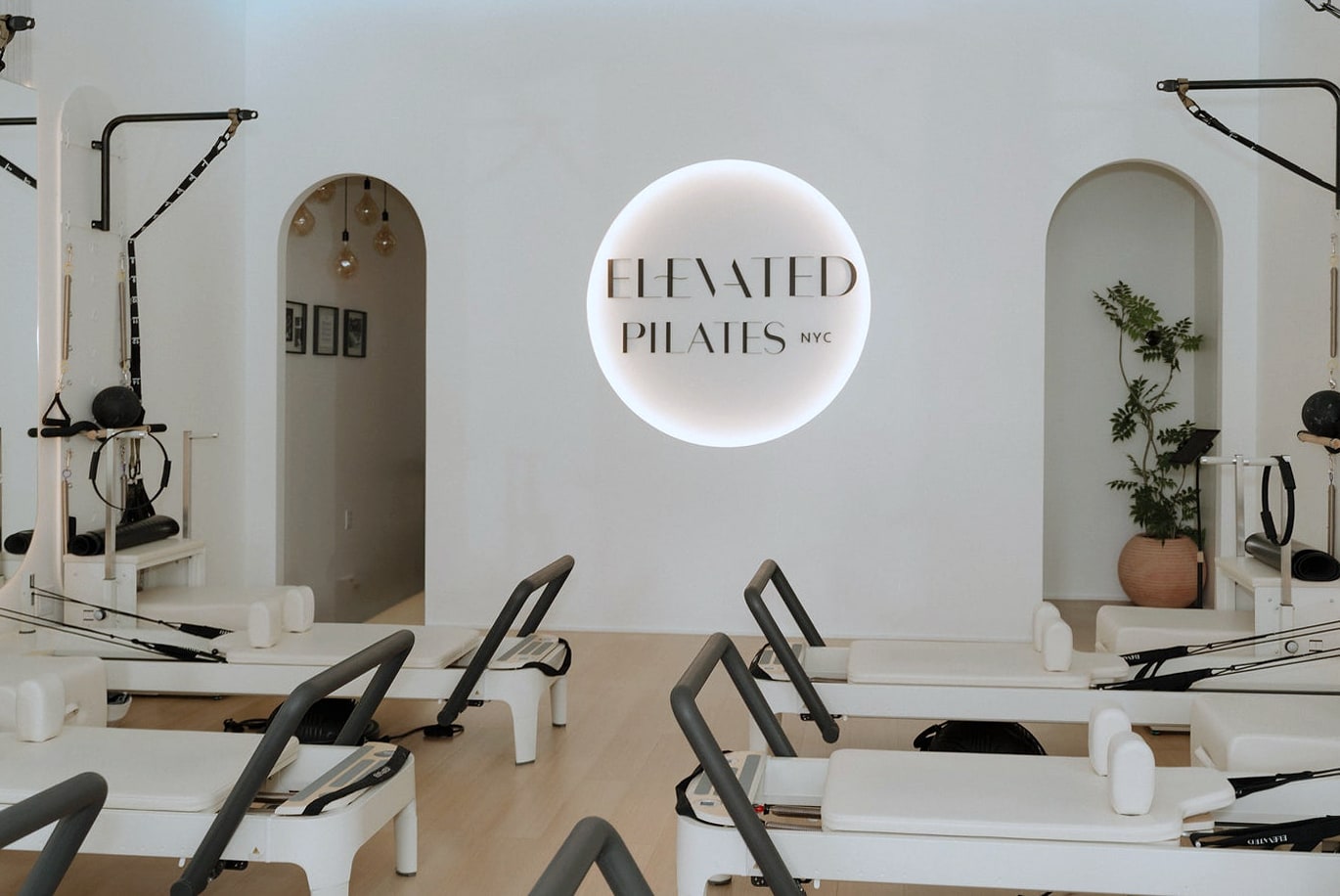 Pilates studio interior with reformers and illuminated Elevated Pilates sign